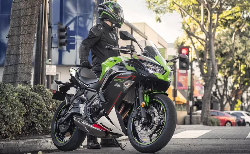 Rider standing behind a Ninja 650